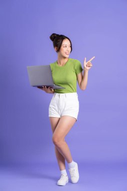 Pembe arka planda poz veren güzel Asyalı kızın tüm vücudu.