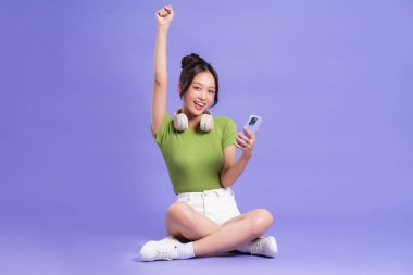 Pembe arka planda poz veren güzel Asyalı kızın tüm vücudu.