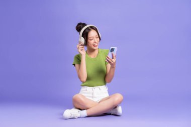 Pembe arka planda poz veren güzel Asyalı kızın tüm vücudu.