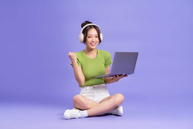 Pembe arka planda poz veren güzel Asyalı kızın tüm vücudu.