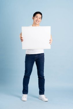 Mavi arka planda poz veren Asyalı adamın portresi