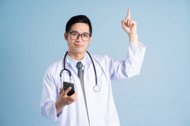 Mavi arka planda Asyalı erkek doktor portresi
