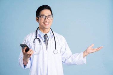 Mavi arka planda Asyalı erkek doktor portresi