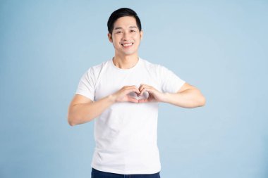 Mavi arka planda poz veren Asyalı adamın portresi