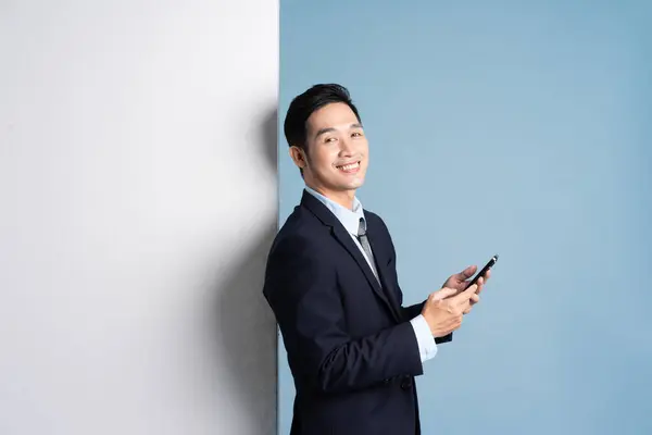 青い背景にスーツを着たアジア人実業家の肖像 — ストック写真