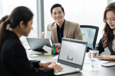 Şirkette birlikte çalışan bir grup Asyalı iş adamının resmi.