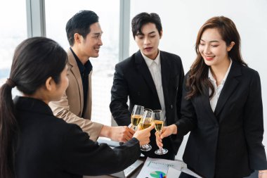 Bir grup Asyalı iş adamı yeni yılı kutlamak için ellerinde şarap kadehleriyle kutluyorlar.