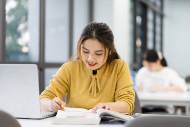 Üniversite kütüphanesinde okuyan Asyalı kız öğrencinin portresi