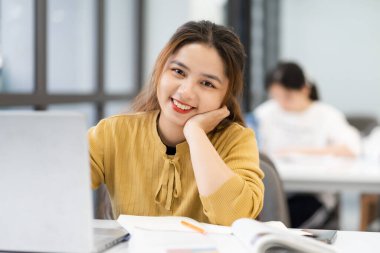 Üniversite kütüphanesinde okuyan Asyalı kız öğrencinin portresi