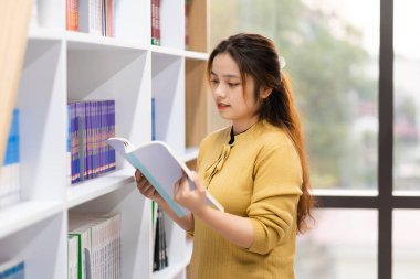 Üniversite kütüphanesinde okuyan Asyalı kız öğrencinin portresi