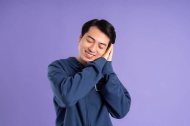 Mor arka planda poz veren Asyalı adamın portresi