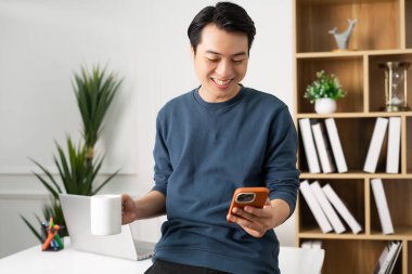 Asyalı bir adamın evde oturup çalışırken görüntüsü