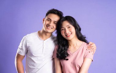 Mor arkaplanda poz veren Asyalı çift görüntüsü