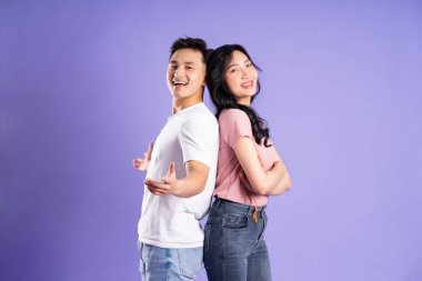 Mor arkaplanda poz veren Asyalı çift görüntüsü