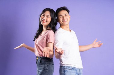 Mor arkaplanda poz veren Asyalı çift görüntüsü
