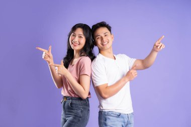 Mor arkaplanda poz veren Asyalı çift görüntüsü