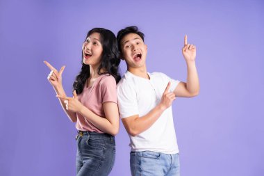Mor arkaplanda poz veren Asyalı çift görüntüsü