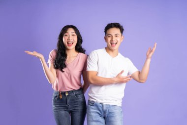 Mor arkaplanda poz veren Asyalı çift görüntüsü