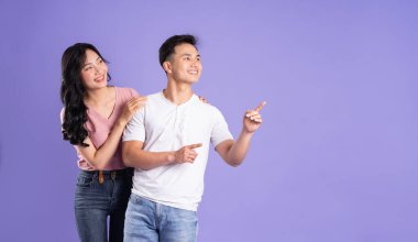 Mor arkaplanda poz veren Asyalı çift görüntüsü