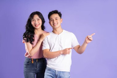 Mor arkaplanda poz veren Asyalı çift görüntüsü