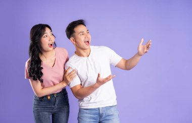 Mor arkaplanda poz veren Asyalı çift görüntüsü