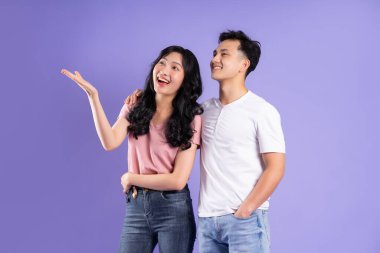 Mor arkaplanda poz veren Asyalı çift görüntüsü