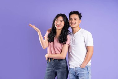 Mor arkaplanda poz veren Asyalı çift görüntüsü