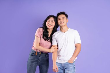 Mor arkaplanda poz veren Asyalı çift görüntüsü