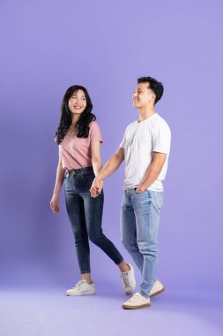 Mor arka planda poz veren Asyalı bir çiftin tüm vücudu.