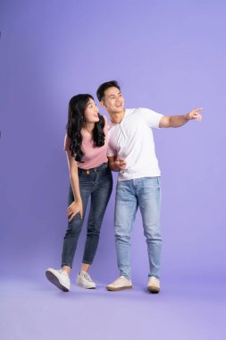 Mor arka planda poz veren Asyalı bir çiftin tüm vücudu.