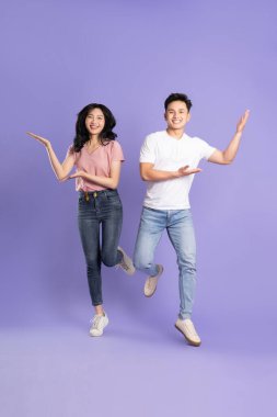 Mor arka planda poz veren Asyalı bir çiftin tüm vücudu.