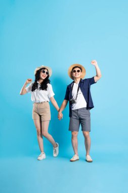 Asyalı çift mavi arka planda izole edilmiş seyahat görüntüsü