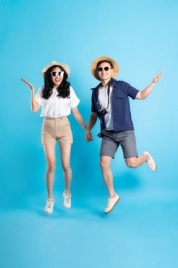 Asyalı çift mavi arka planda izole edilmiş seyahat görüntüsü