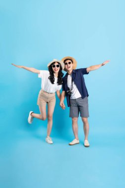 Asyalı çift mavi arka planda izole edilmiş seyahat görüntüsü