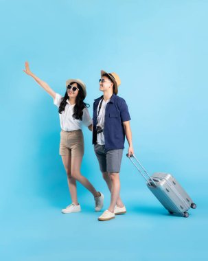 Asyalı çift mavi arka planda izole edilmiş seyahat görüntüsü