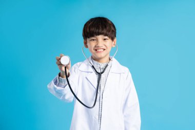 Asyalı çocuk portresi mavi arka planda poz veriyor