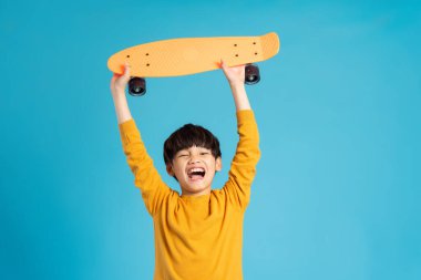 Asyalı çocuk portresi mavi arka planda poz veriyor