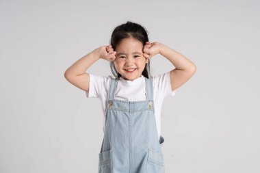 Beyaz arka planda poz veren Asyalı güzel bir kızın portresi.