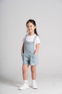 Beyaz arka planda poz veren Asyalı güzel bir kızın portresi.