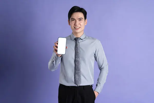 Portrait of Asian male businessman posing on purple background