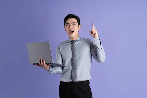 Portrait of Asian male businessman posing on purple background
