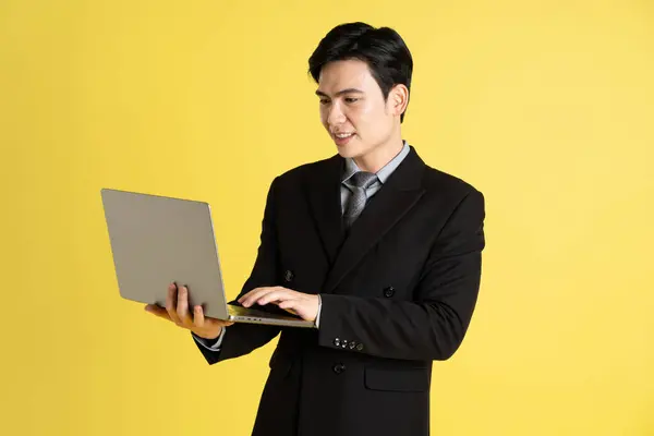 アジアの男性ビジネスマンの肖像画 スーツを着て黄色の背景にポーズをかける ストックフォト