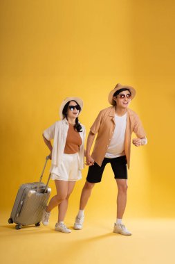 Sarı arka planda poz veren çift portresi, yaz, seyahat
