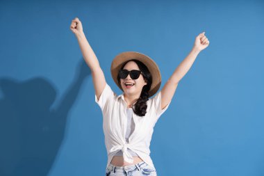 Mavi arka planda poz veren Asyalı bir kızın portresi. Yazın seyahat ediyor.