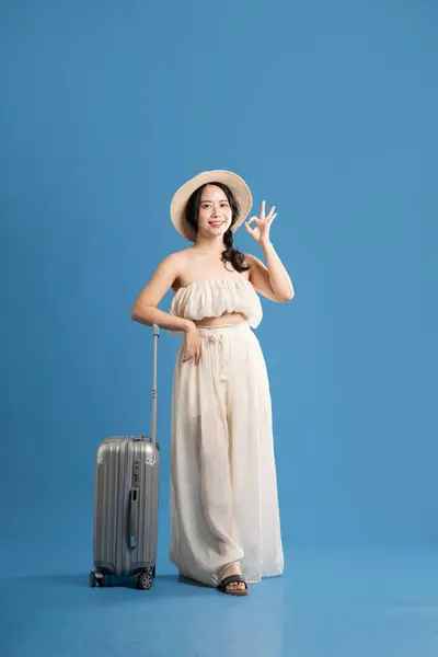 stock image Portrait of asian girl posing on blue background, traveling in summer