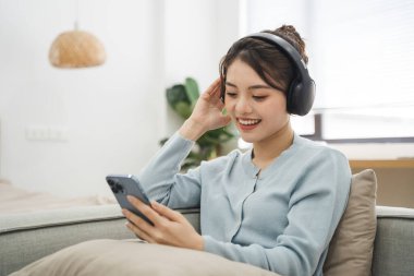 Evdeki kanepede oturan Asyalı kadının portresi.