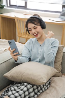 Evdeki kanepede oturan Asyalı kadının portresi.