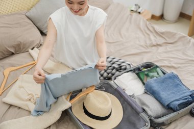 Seyahat etmek için bavul hazırlayan kadın resmi