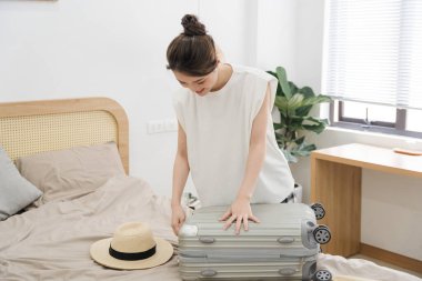 Seyahat etmek için bavul hazırlayan kadın resmi