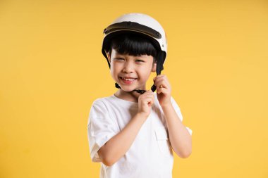 Sarı arka planda poz veren sevimli Asyalı çocuk portresi.